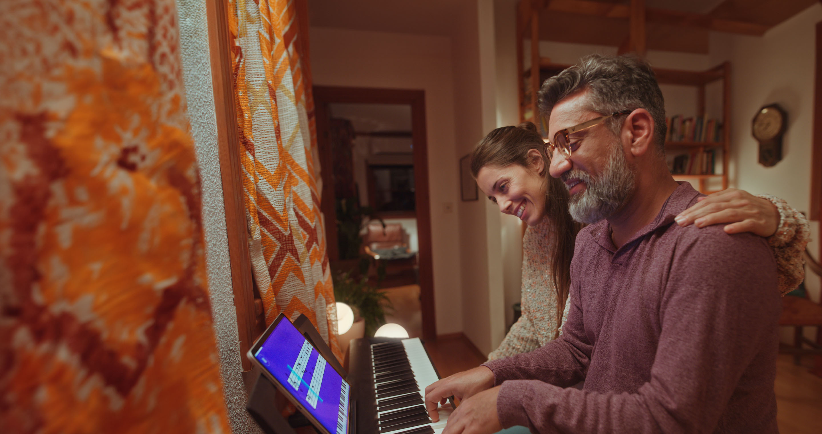 A young couple playing the piano using a tablet App